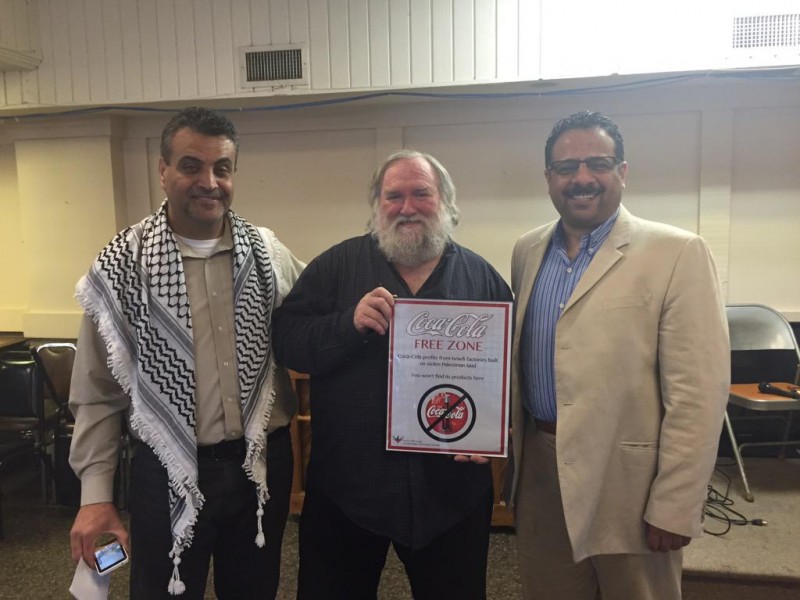 Dave Bicking (center), owner of building that is home to peace and justice organizations presented with plaque recognizing his is the first building in Minnesota to be a part of the national campaign to boycott Coca-Cola.