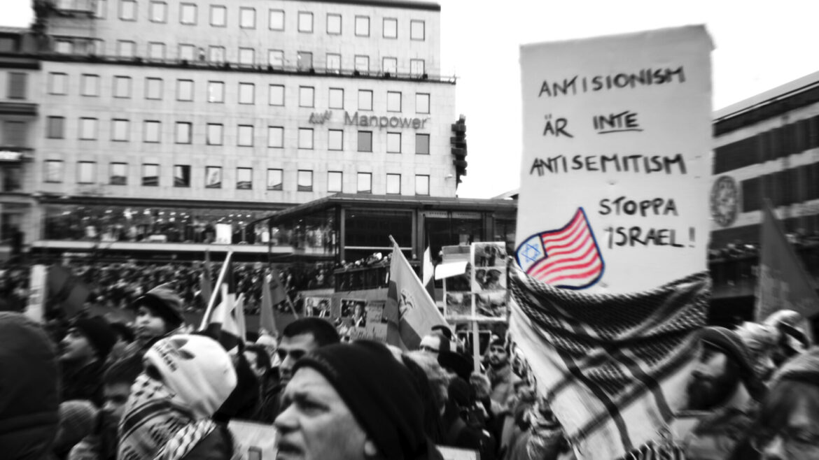Protesters in Stockholm, Sweden, hold a sign reading "Anti-Zionism is not antisemitism. Stop Israel," Jan. 10, 2009. (Robin/Flickr Commons)